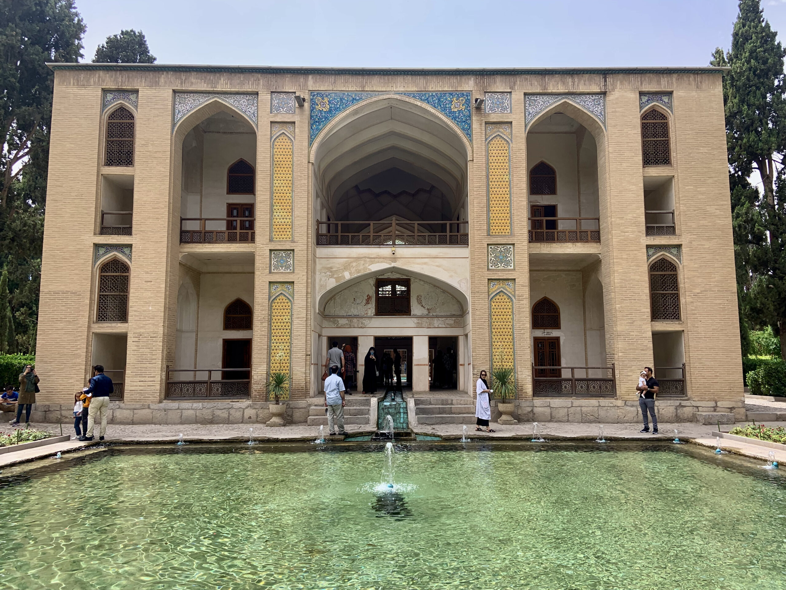 A classical Persian garden with cypress trees and an airy pavilion