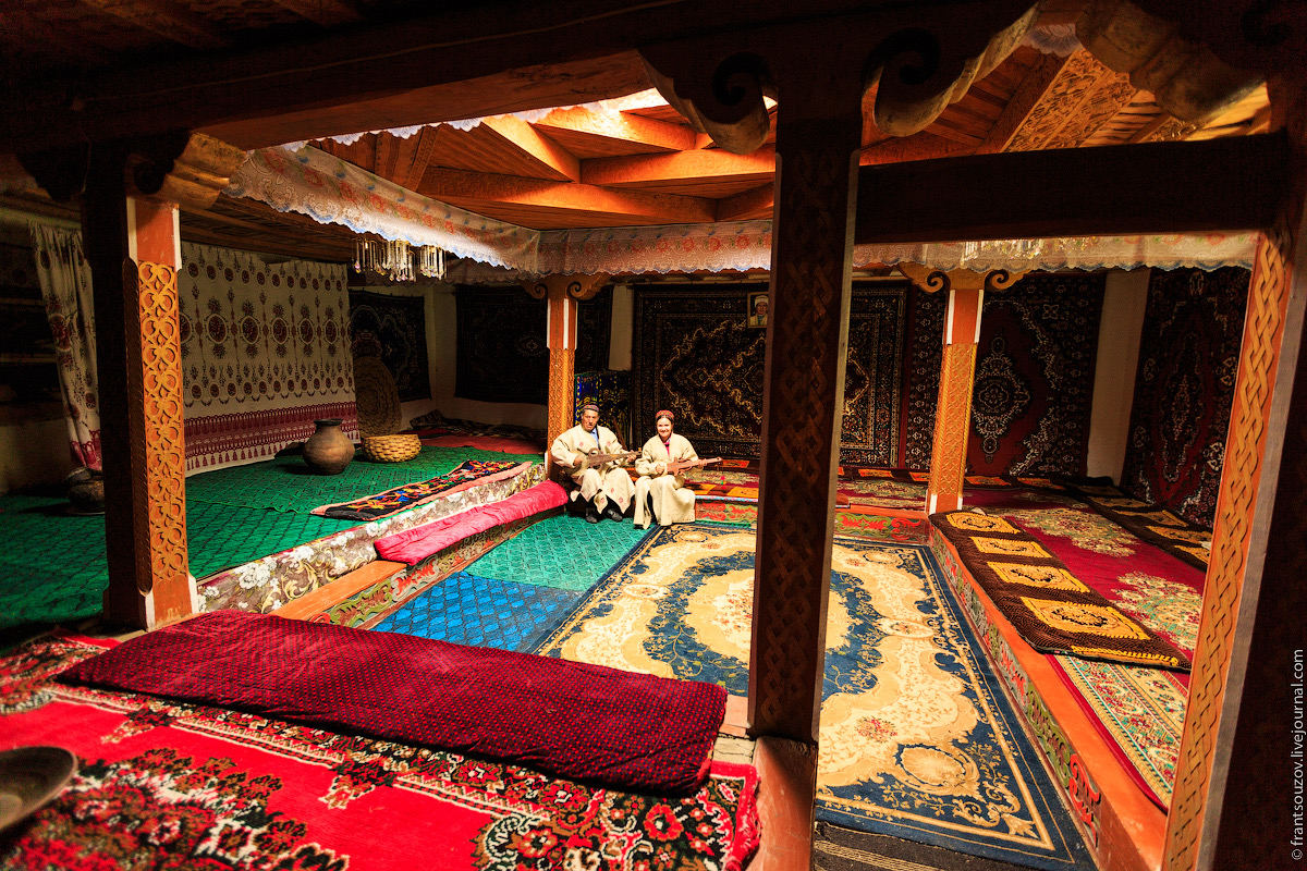 The room is decorated with traditional handwoven carpets