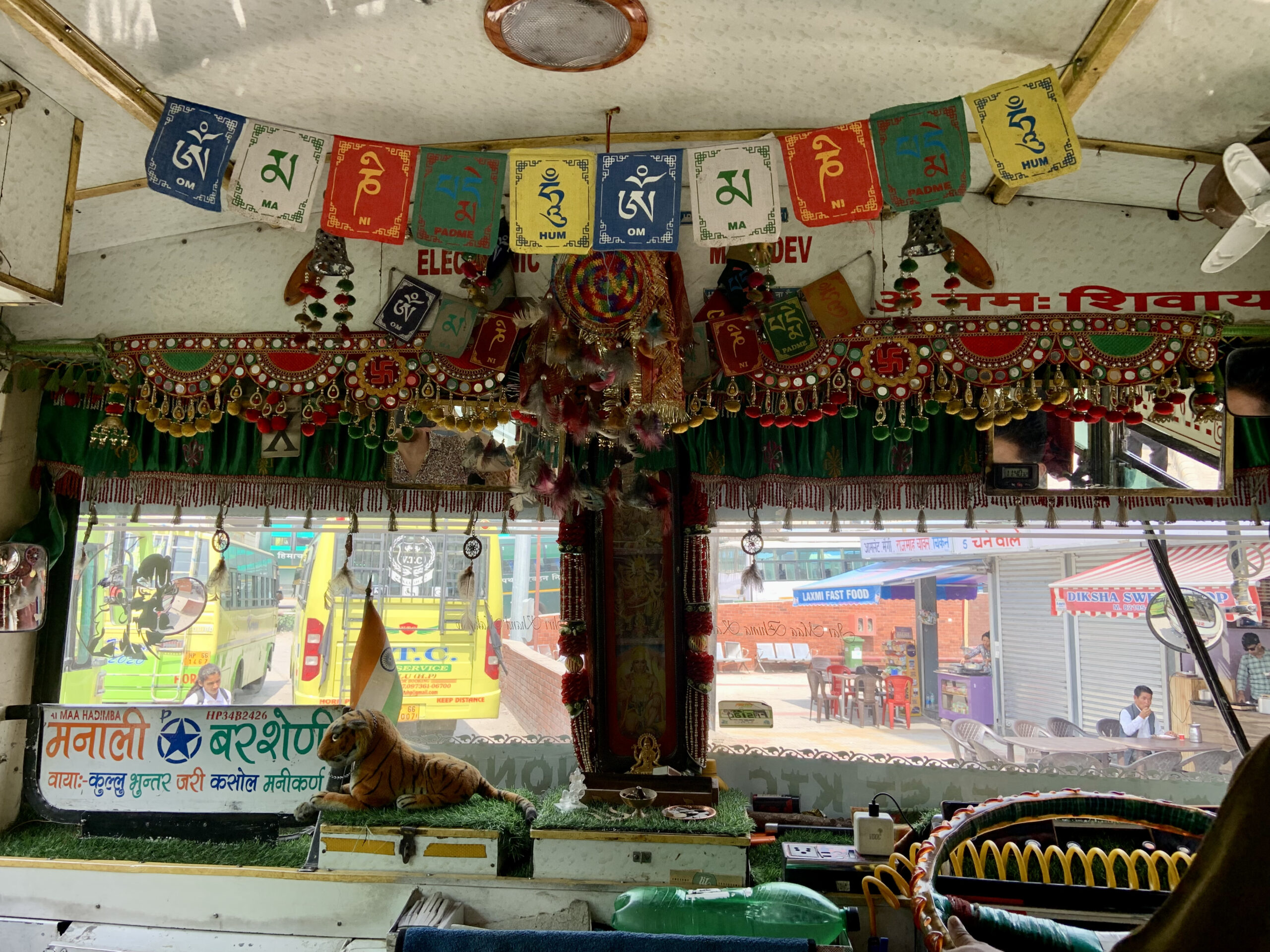 Tibetan prayer flags and statues of gods are said to bring good luck to the bus driver